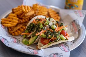 Plate of veggie tacos with waffle fries