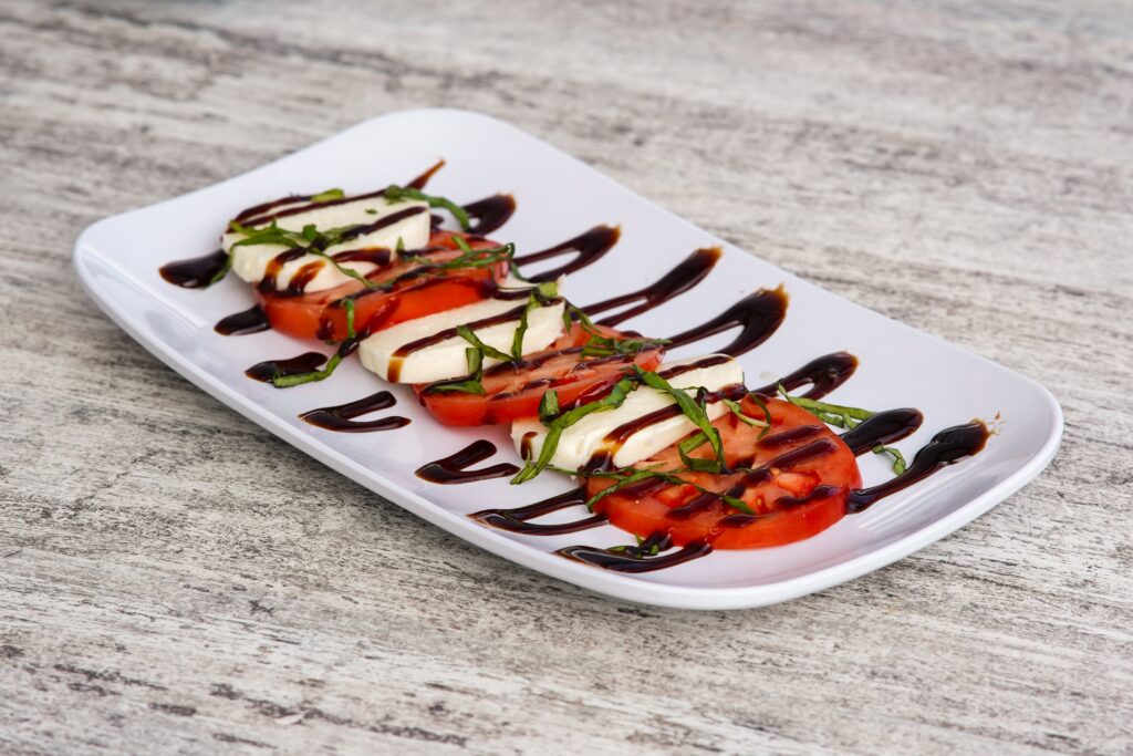 A caprese salad on a white plate.