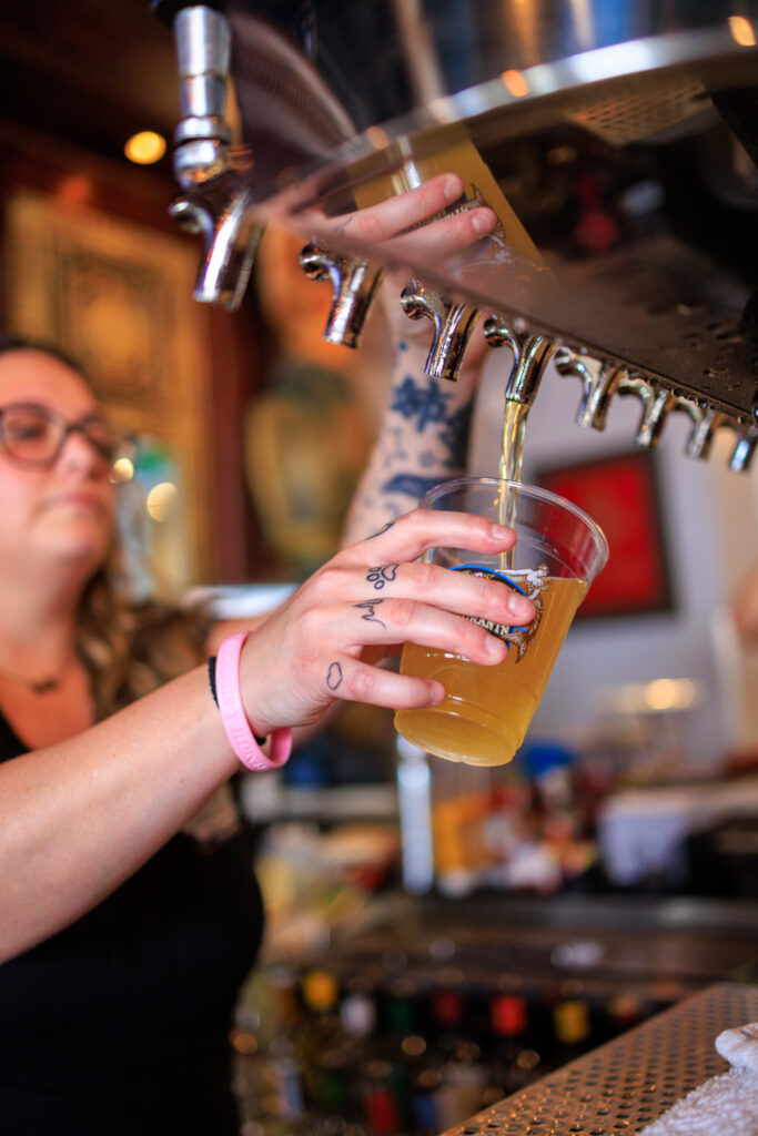 A bartender pouring a beer from the tap.